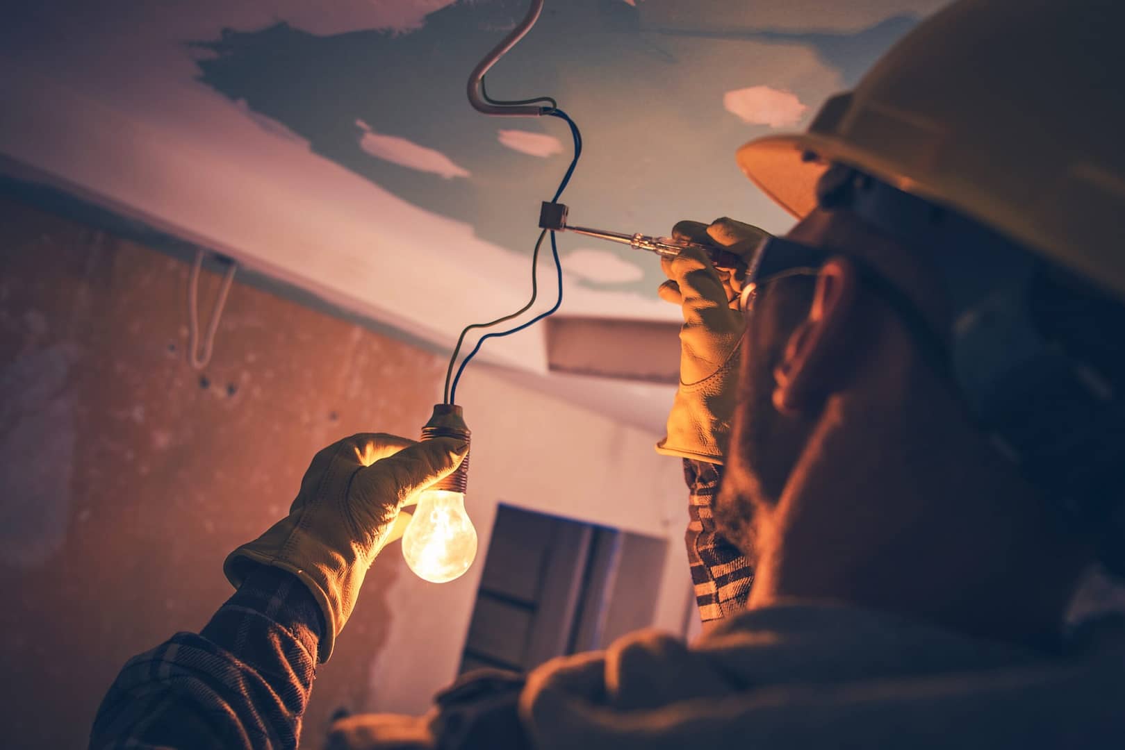 An electrician makes an adjustment with a wire. Electricians who advertise in LocalSplash see an increase in visibility to their business and an increase in leads.