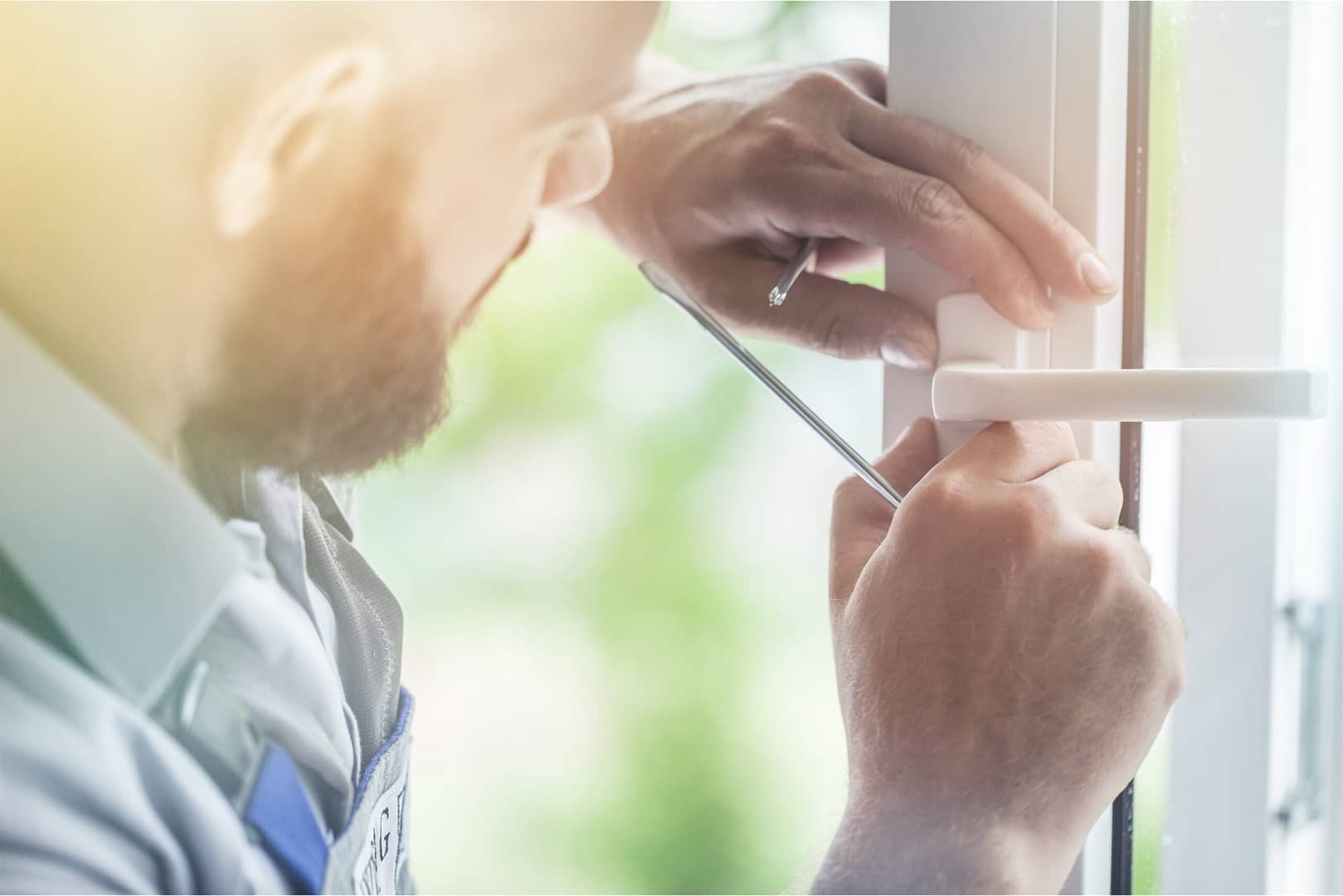 Image of a man using a screwdriver to fix a door with screws, ensuring prevention of unintended lockouts.