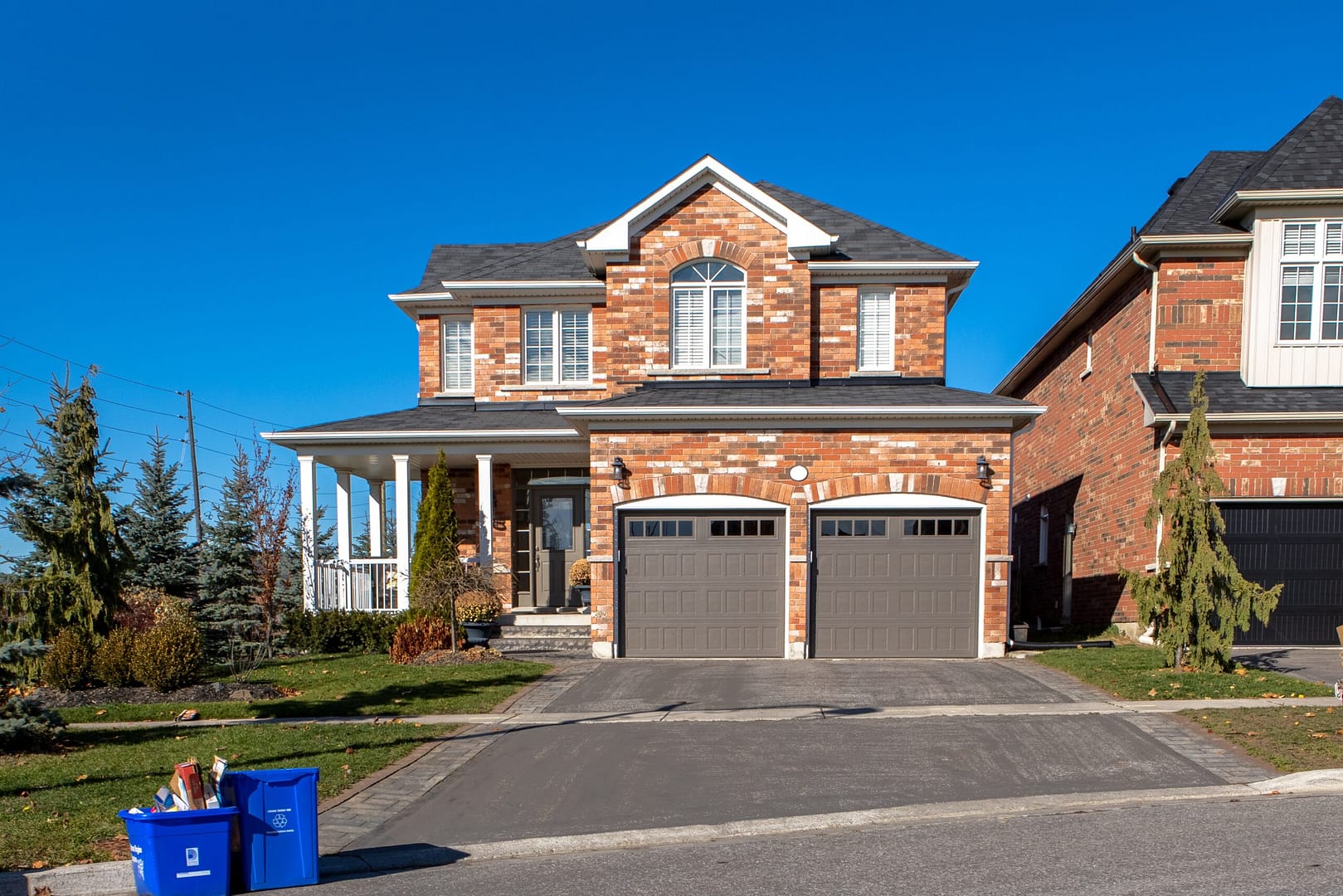 A suburban house with a spacious two-door garage and an expansive driveway leading up to the entrance