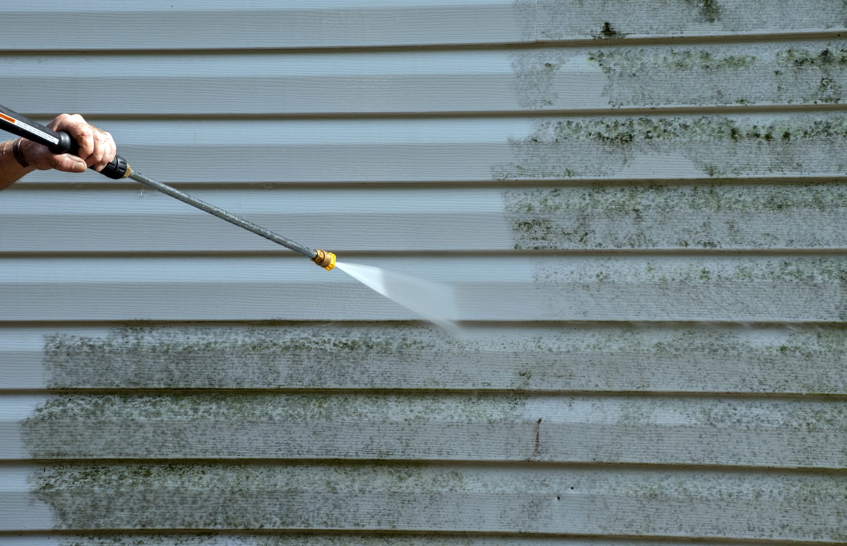 Closeup view of effective pressure washing technique showcasing clean exterior siding – a prime example of our marketing client's results.