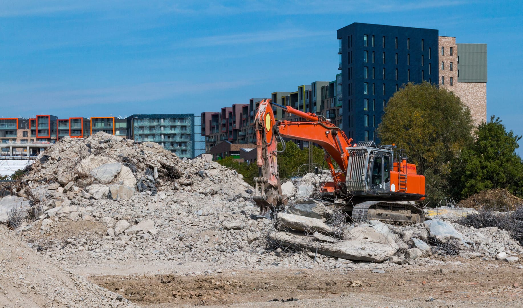 Demolition site with heavy machinery clearing the land to make way for new construction.