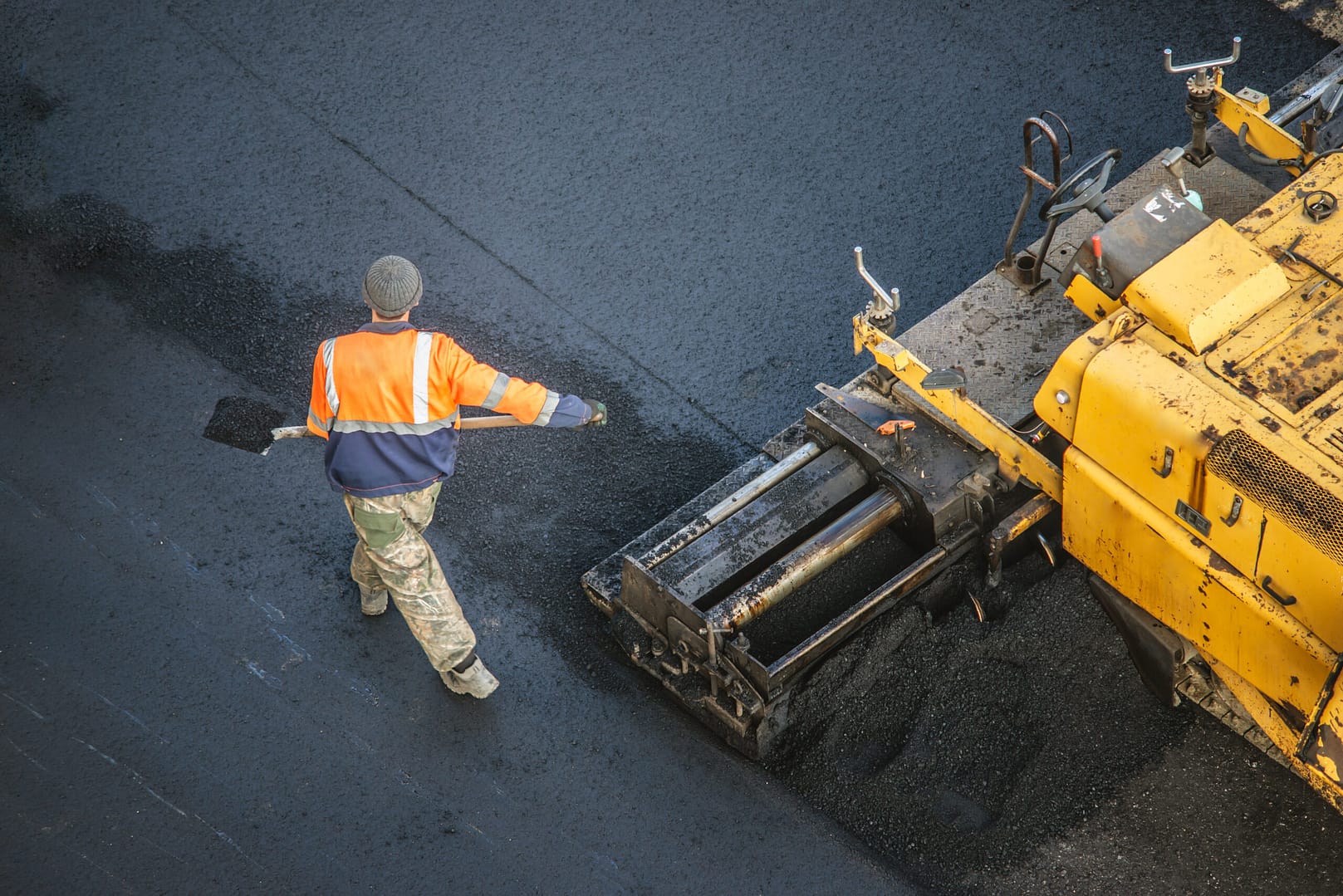 Road crew using heavy machinery to lay asphalt, highlighting the precision and quality in paving company projects.