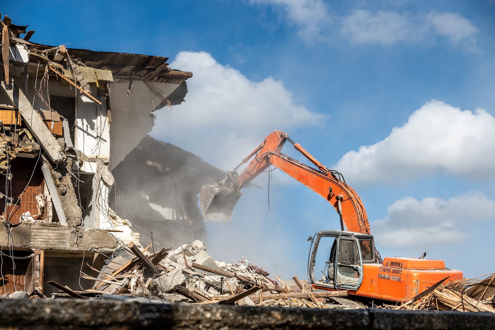 Backhoe actively engaged in a large-scale demolition, illustrating the diverse projects catered to by excavation marketing strategies.