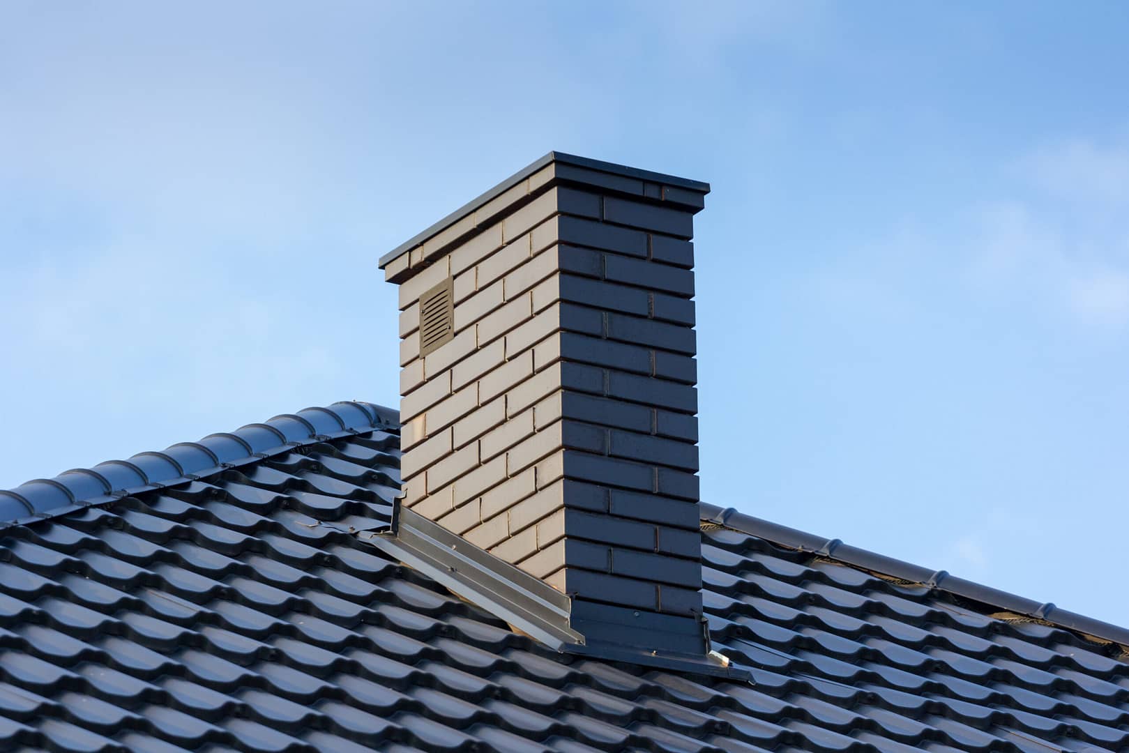 Detail-oriented roofing services, emphasizing precision finishes around chimneys and intricate areas.