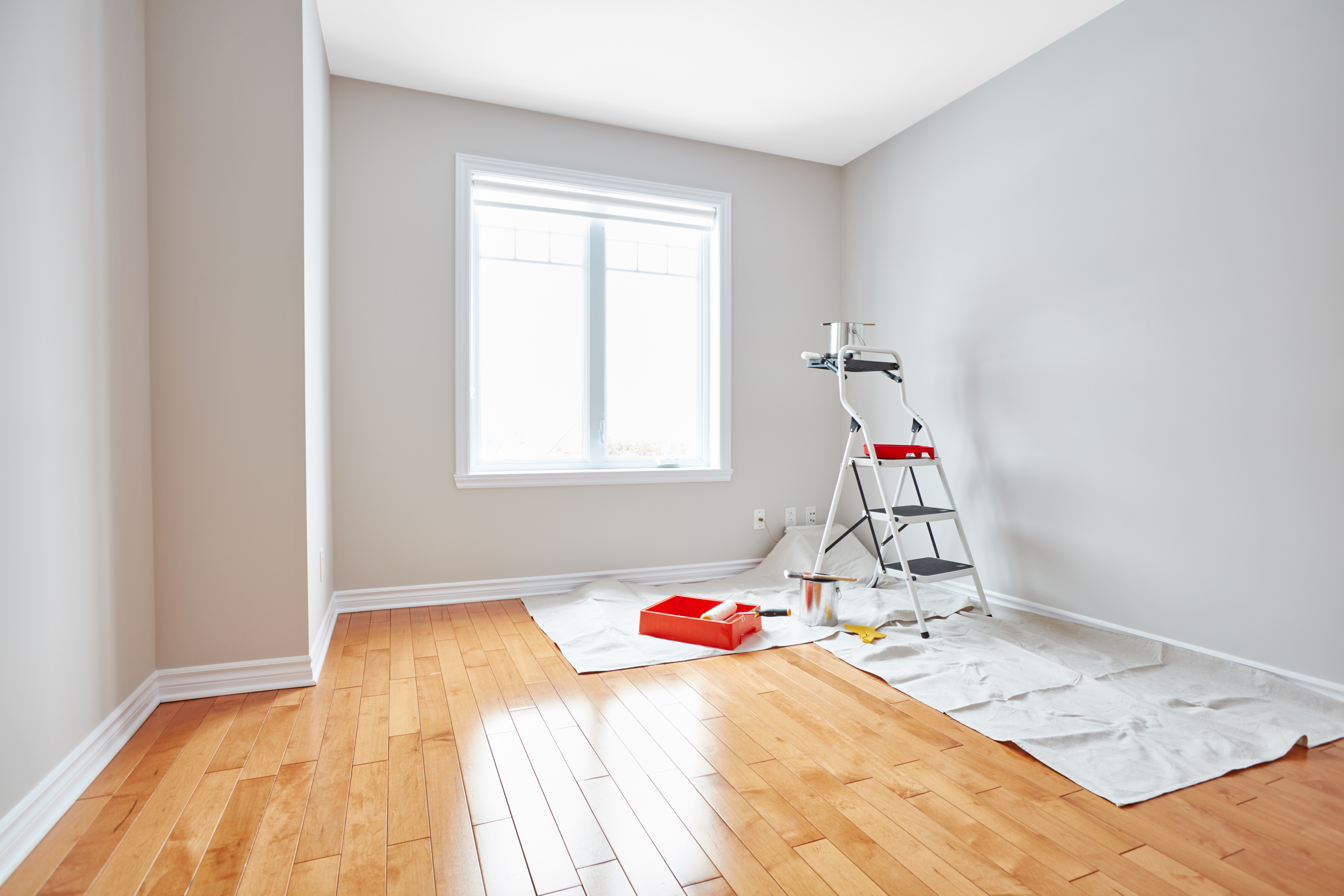 A vacant room with hardwood floors, a ladder and painting materials. Just as this room awaits a transformation, your painting business can undergo a digital makeover to attract more clients.
