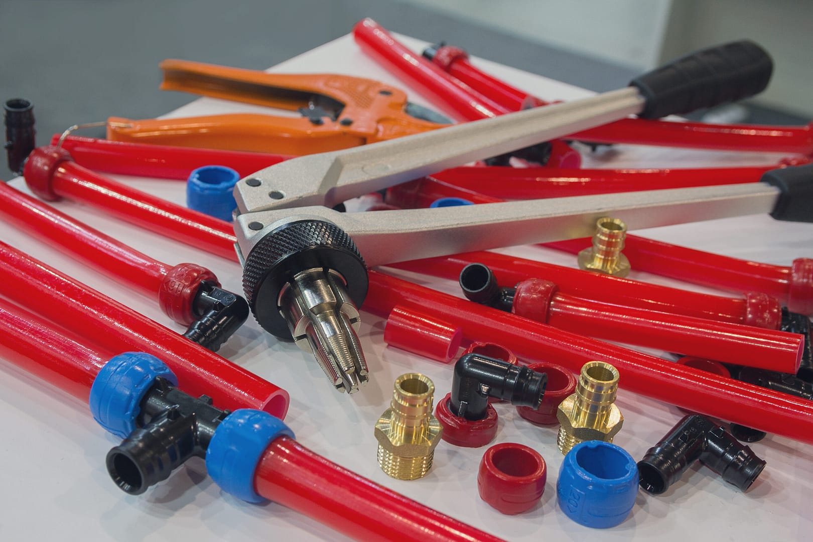 Various PEX water pipes and plumbing mounting tools neatly arranged on a table, ready for installation and plumbing work.