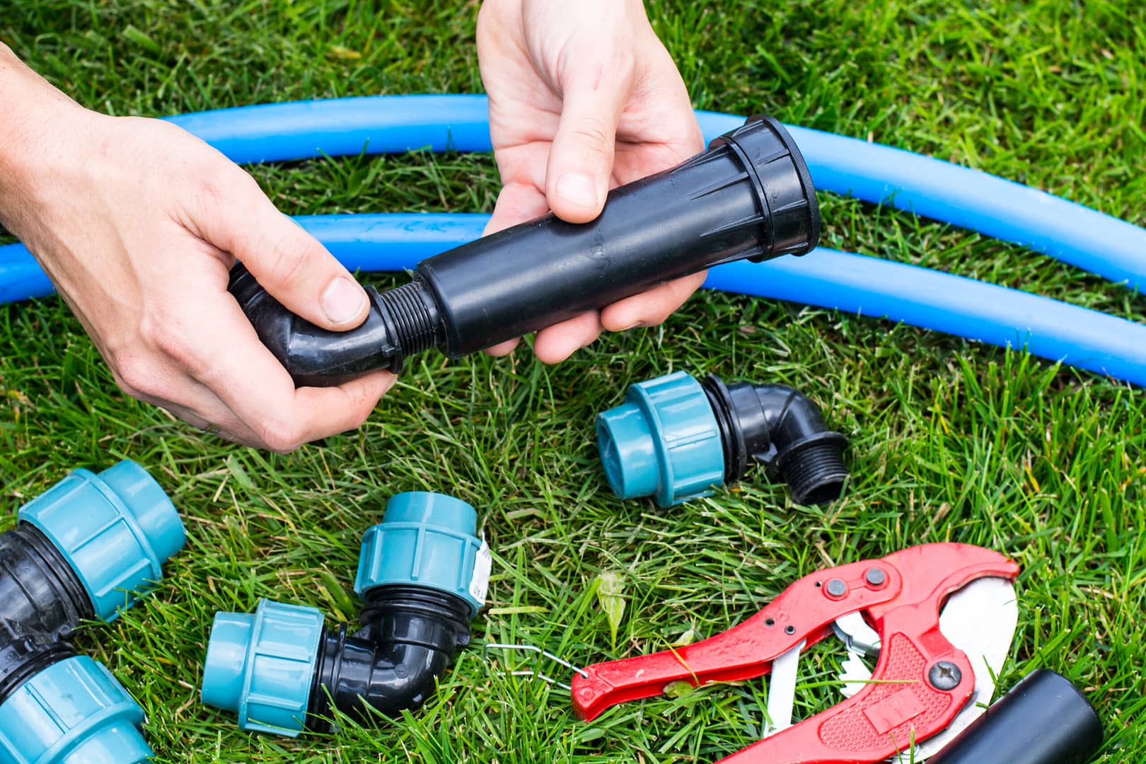 Colorful plastic pipes arranged neatly in a grass for an automatic garden irrigation system, showcasing efficient water distribution and gardening technology.